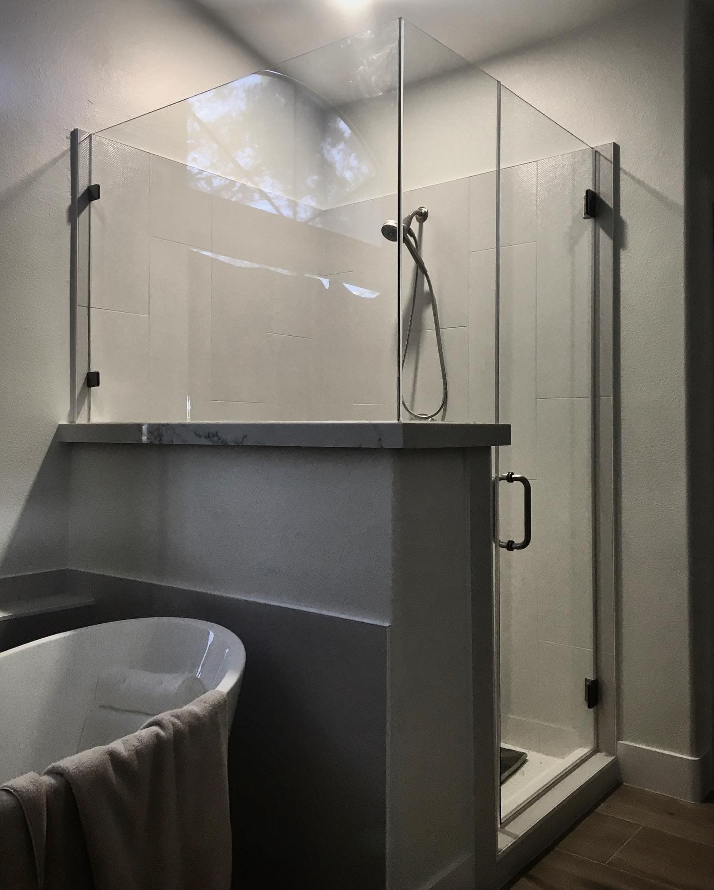 Luxury frameless shower door installation in modern Las Vegas bathroom with chrome hardware and clear glass